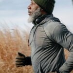 black pensioner in sportswear jogging in sunny autumn day