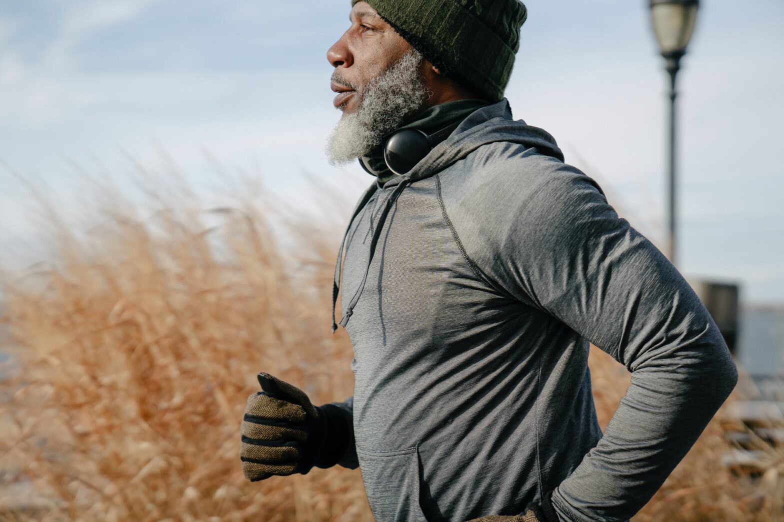 black pensioner in sportswear jogging in sunny autumn day